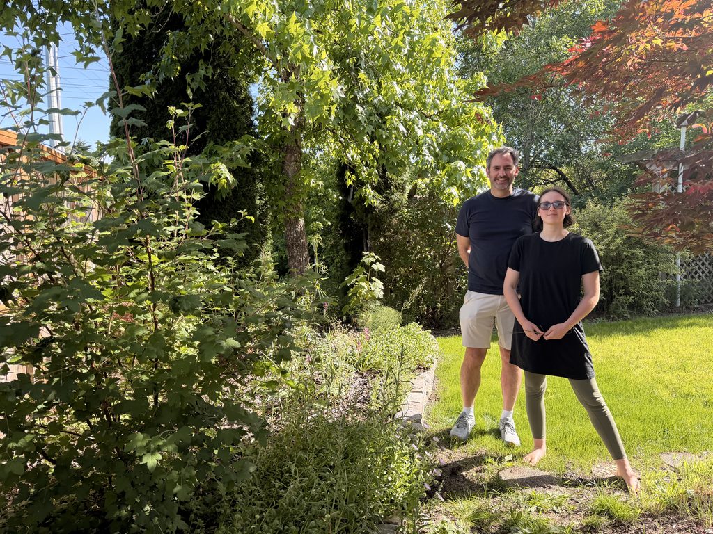 Brian and Summer Torres standing together in their native plant garden in Portland